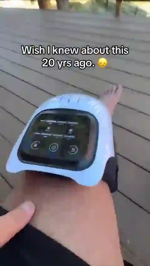 A GlowKnee owner outdoors with the massager on the knee, thumb on the control panel