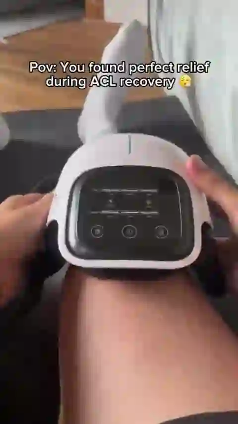 A GlowKnee owner at home wearing the massager on the knee, adjusting the buttons